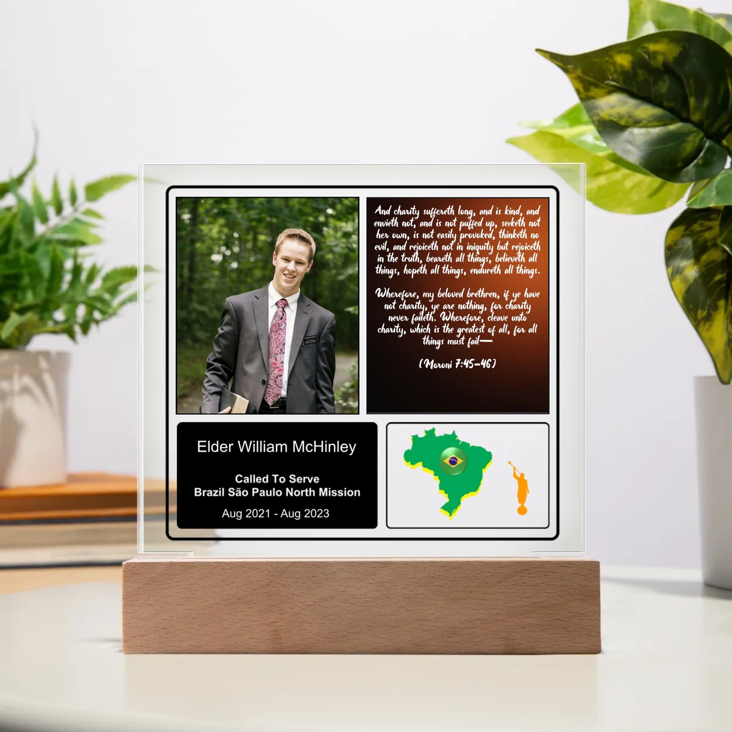 An acrylic square plaque with a printed portrait of a man and text, mounted on a wooden base with a green map outline in the background.