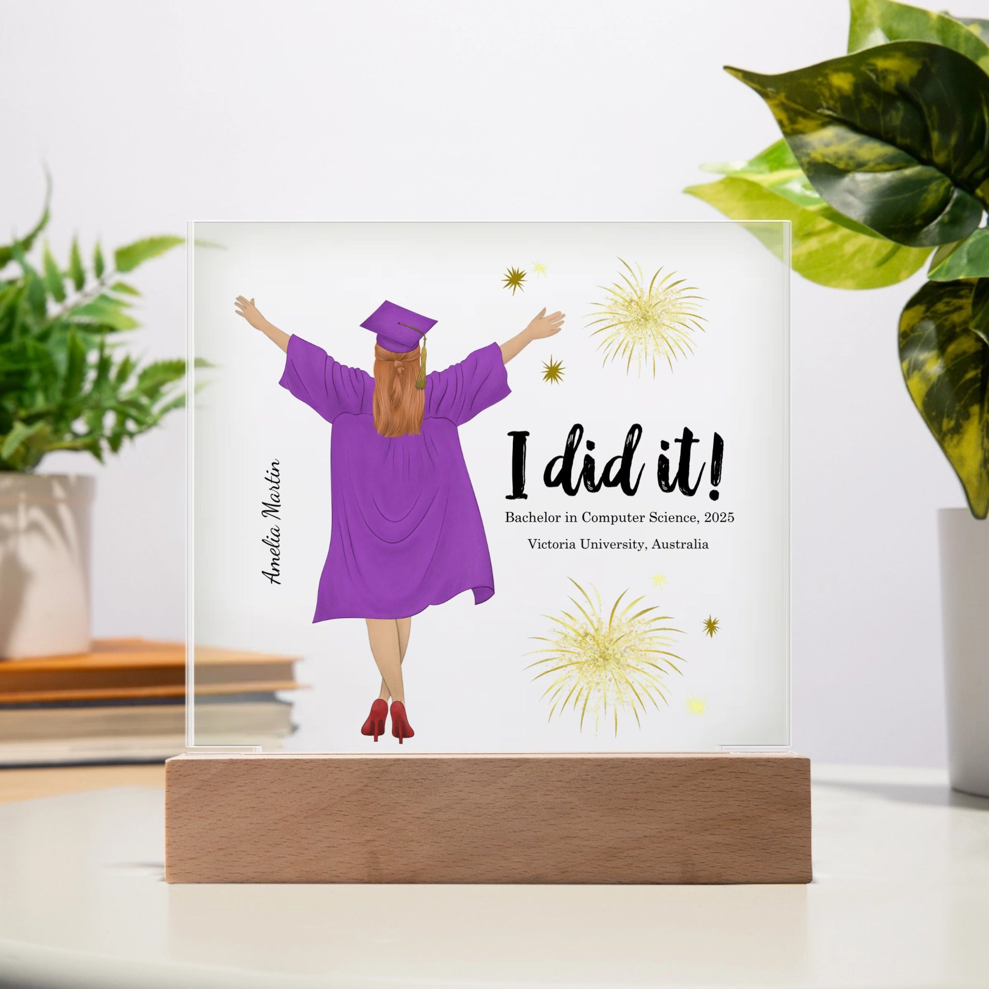 Graduation-themed decorative plaque with a person in a purple gown and cap, 'I did it!' text, and fireworks on a white background.