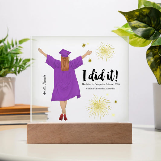 Graduation-themed decorative plaque with a person in a purple gown and cap, 'I did it!' text, and fireworks on a white background.