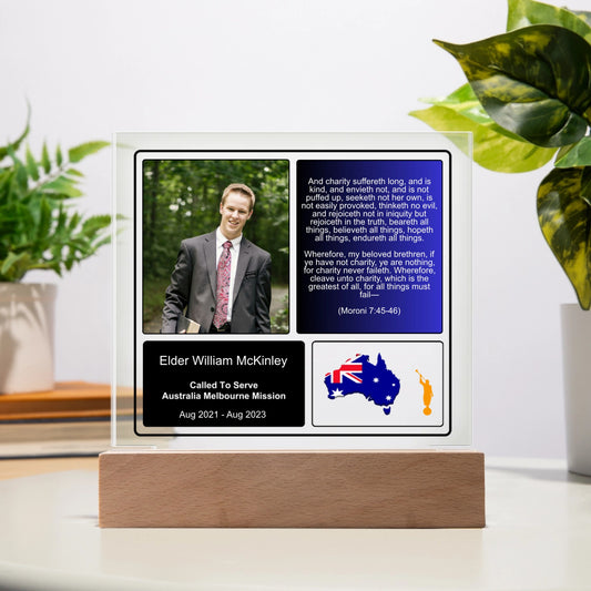 A custom missionary plaque with a battery-powered LED base, featuring a photo, scripture, and service details. The plaque is square, with a wooden base and acrylic construction.